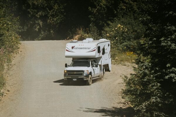 Photo by Luke Miller A truck driving down a dirt road with an rv on it