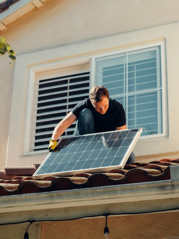 Man in Black Shirt Sitting on Brown Roof